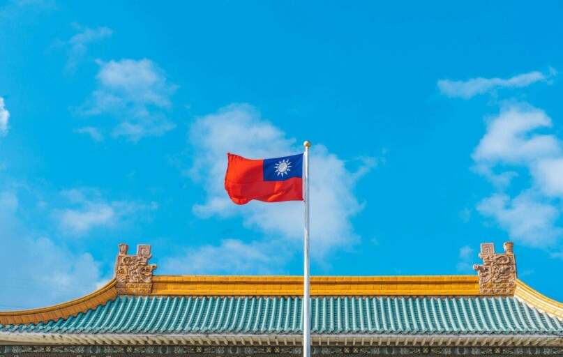a red and blue flag on top of a building