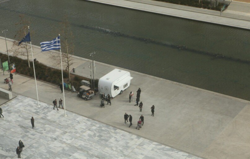 a group of people standing around a white truck