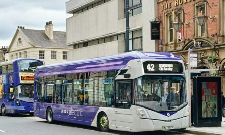 A couple of buses that are sitting in the street