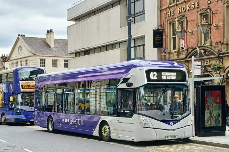 A couple of buses that are sitting in the street