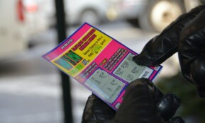 a person in black gloves holding a ticket