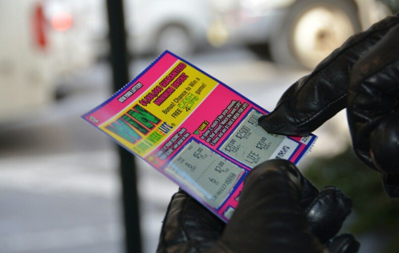 a person in black gloves holding a ticket