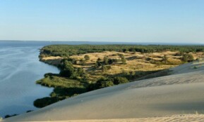 a large body of water surrounded by sand dunes