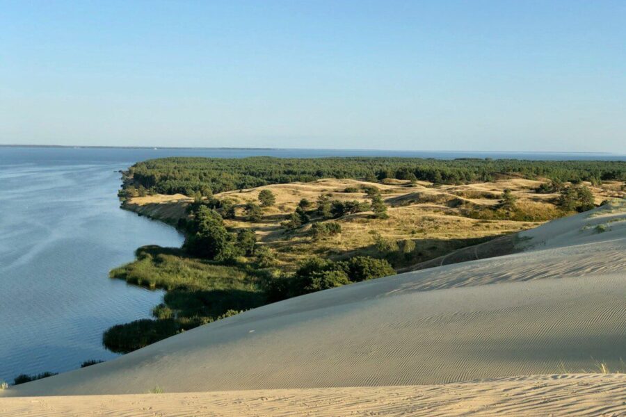 a large body of water surrounded by sand dunes