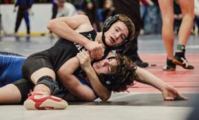 Two young men wrestling on a mat