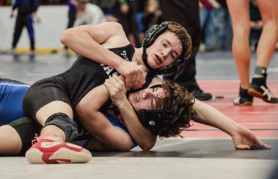 Two young men wrestling on a mat