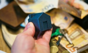 Buying a house with money, keys, and coins.