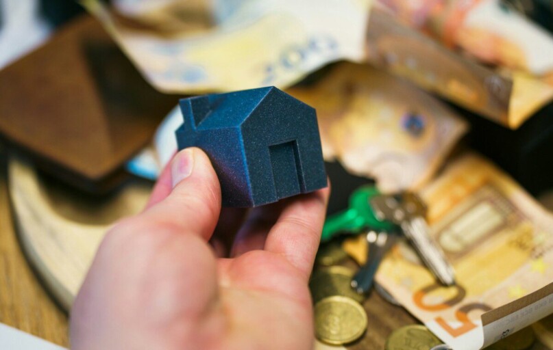 Buying a house with money, keys, and coins.