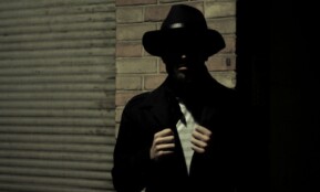 man wearing black fedora hat and black suit jacket