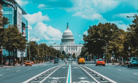 wide road with vehicle traveling with white dome building