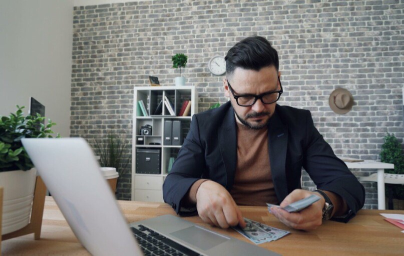 a man sitting at a table in front of a laptop