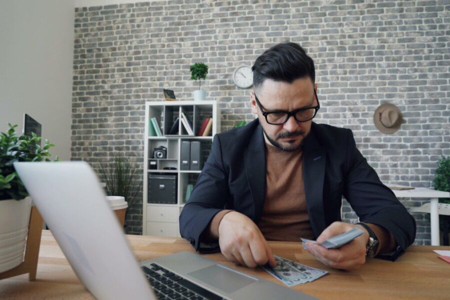 a man sitting at a table in front of a laptop