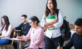 woman carrying white and green textbook