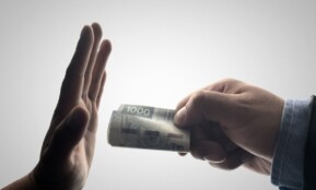 a person holding a stack of cash