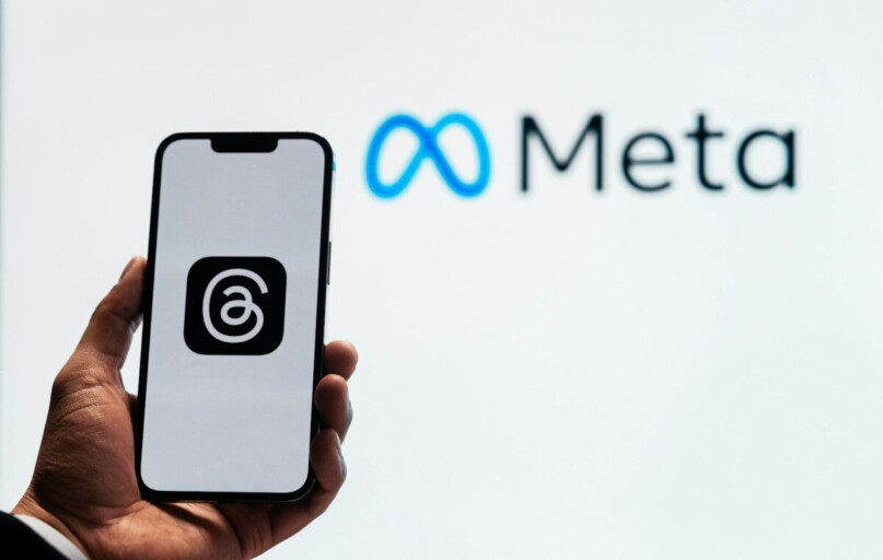 a person holding up a cell phone in front of a sign