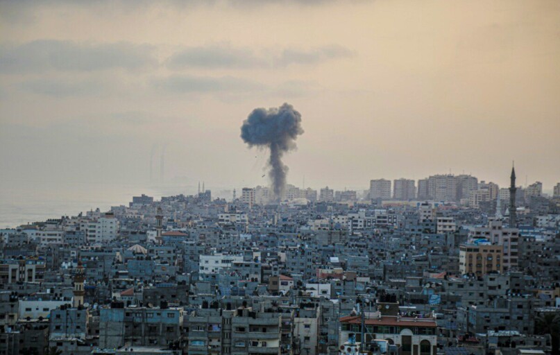 smoke billows from a factory in a city