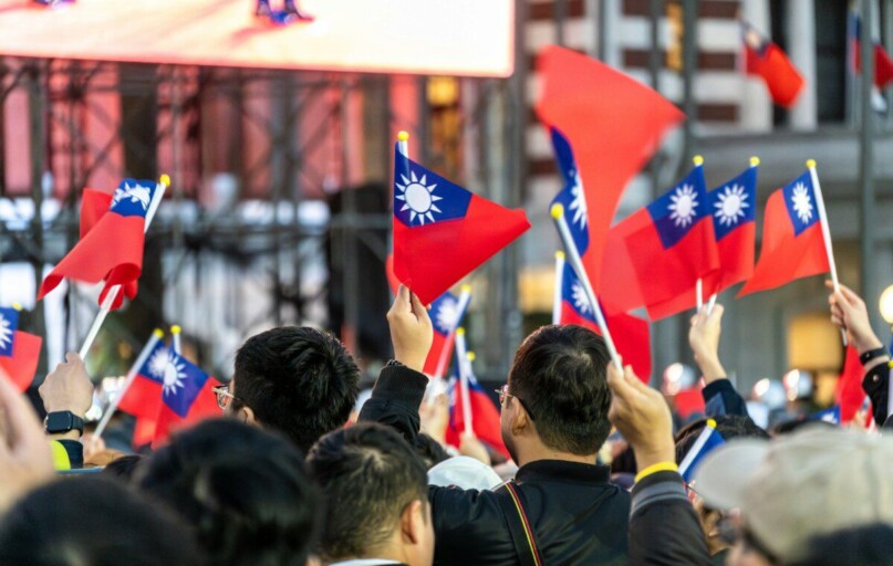 A crowd of people holding up red and blue flags