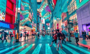 people walking on road near well-lit buildings