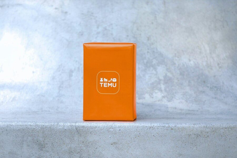 Orange box with white logo on concrete surface.