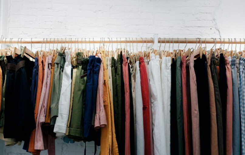 assorted-color clothes lot hanging on wooden wall rack