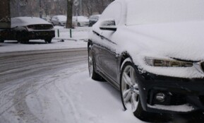 a car covered in snow on a snowy street