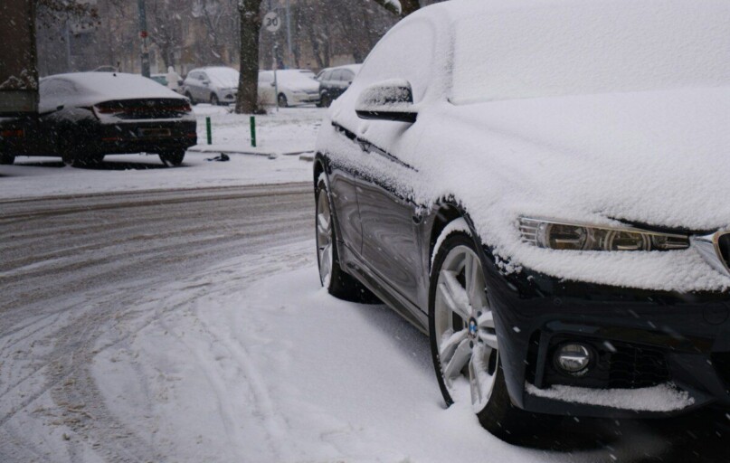a car covered in snow on a snowy street