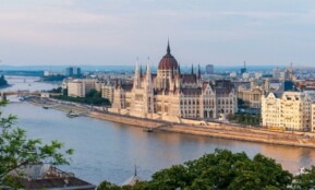 brown concrete building near body of water during daytime