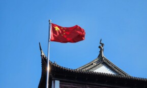 A chinese flag flying on top of a building