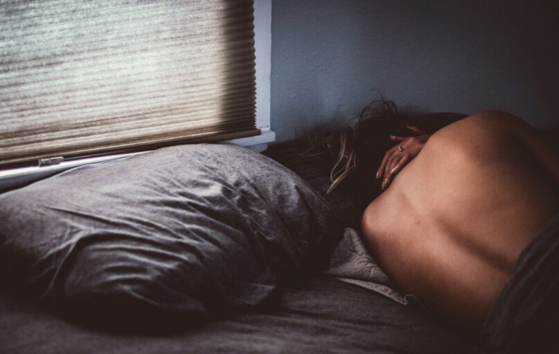 topless woman lying on bed
