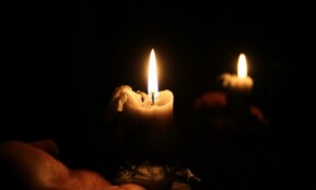 a person holding a lit candle in their hand
