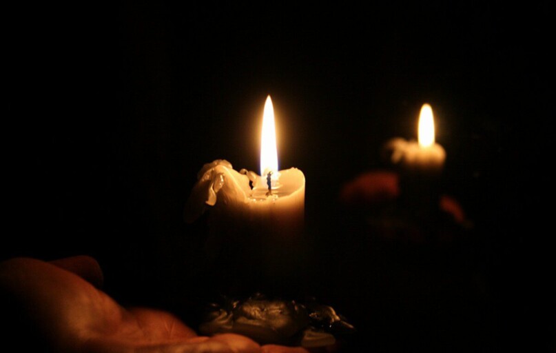 a person holding a lit candle in their hand