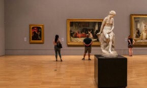 woman in black long sleeve shirt standing near white statue