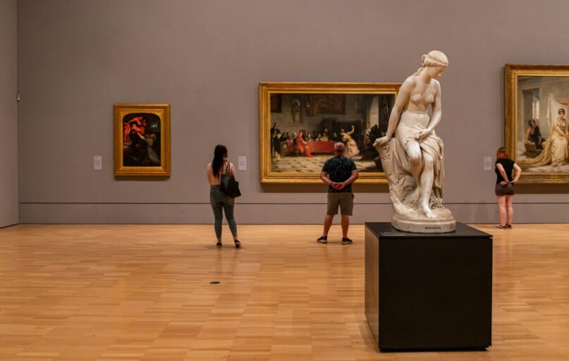 woman in black long sleeve shirt standing near white statue