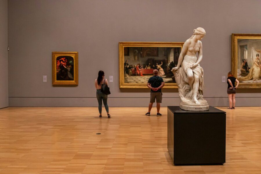 woman in black long sleeve shirt standing near white statue