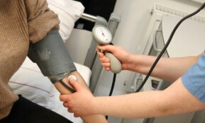 A person with a blood pressure device in their hand
