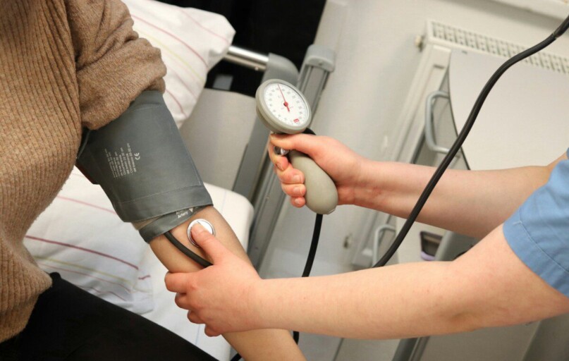 A person with a blood pressure device in their hand