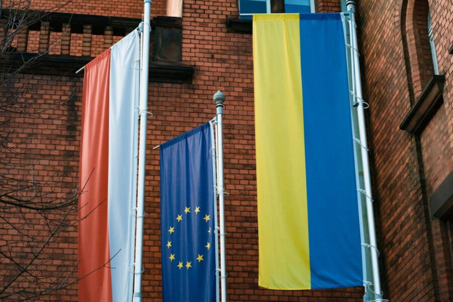a brick building with three flags hanging from it's sides