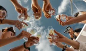 people holding clear glass bottles during daytime