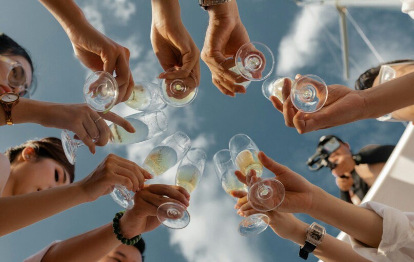 people holding clear glass bottles during daytime