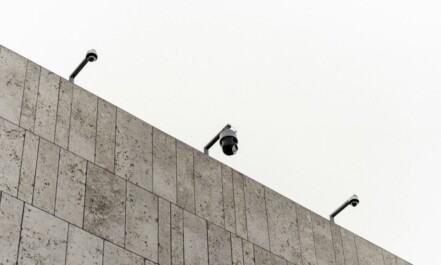 a couple of cameras sitting on top of a wall