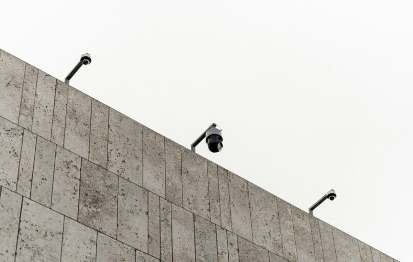 a couple of cameras sitting on top of a wall