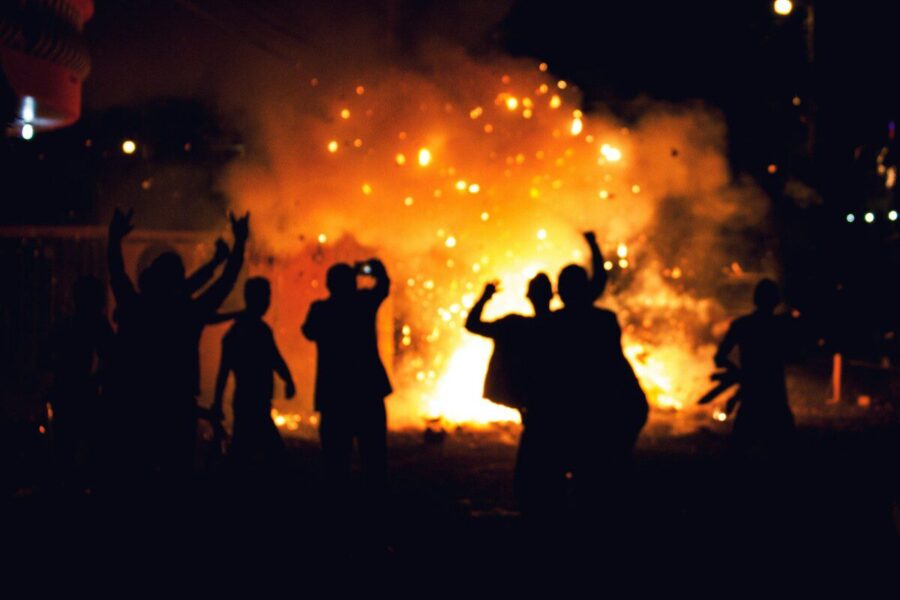 silhouette of people standing on field with fireworks