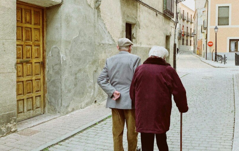 man and woman walking near closed wooden door