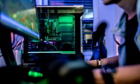 a man sitting in front of a computer monitor