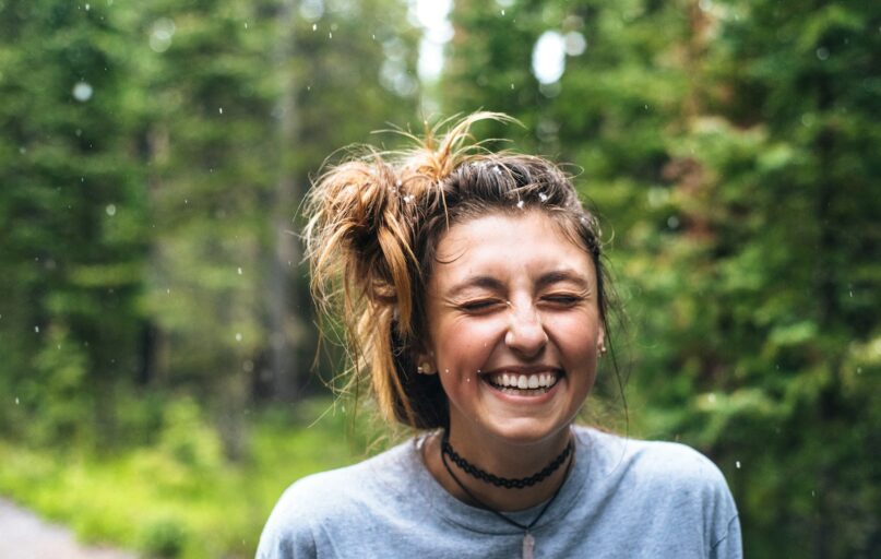 woman smiling near tree outdoor during daytime