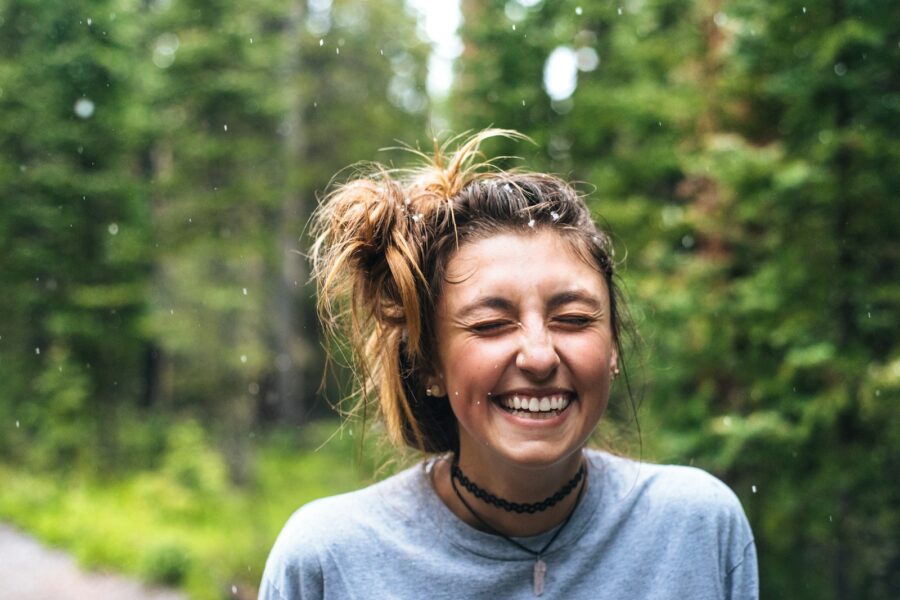 woman smiling near tree outdoor during daytime
