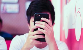 man in white crew neck t-shirt holding black iphone 5