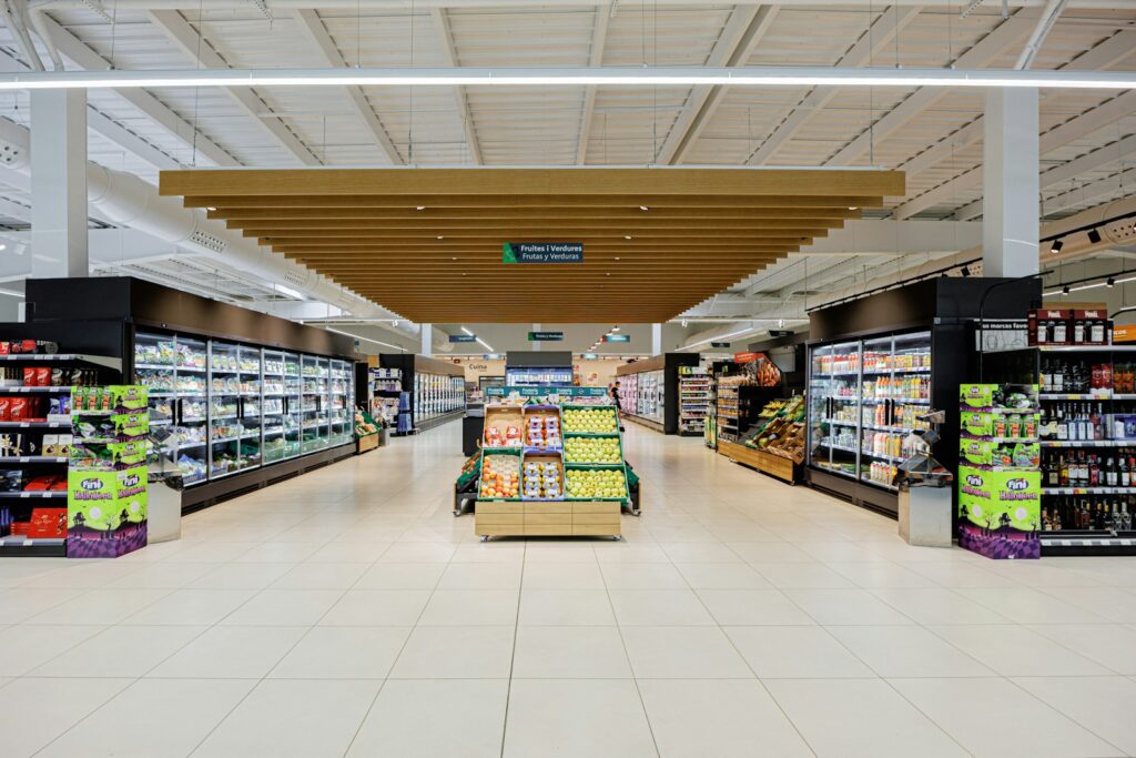 A brightly lit supermarket aisle with shelves of products.