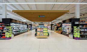 A brightly lit supermarket aisle with shelves of products.