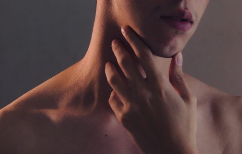 topless woman with left hand on her chin